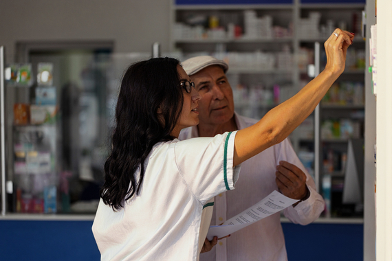 Pharmacy technician filling prescription at counter